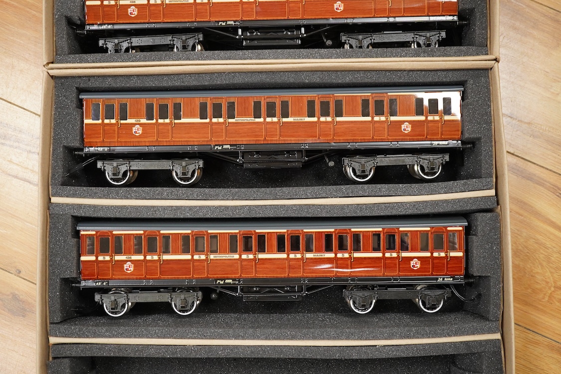 A boxed 0 gauge Darstaed tinplate Metropolitan Railway set of bogie coaches, a rake of five coaches in teak livery including; two Brake Thirds, two Full Thirds, and a Full First, fitted with internal lighting throughout